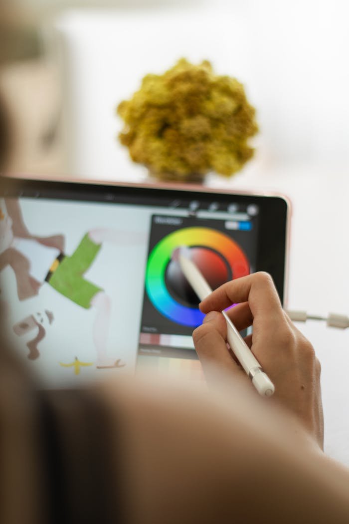 Close-up of a hand using a stylus on a digital drawing tablet for art creation.